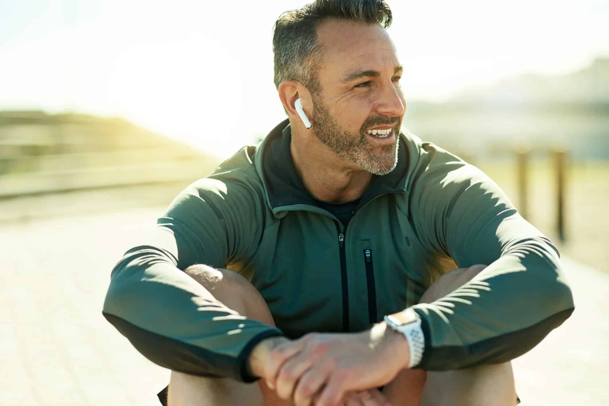 man with ear piece sitting outside