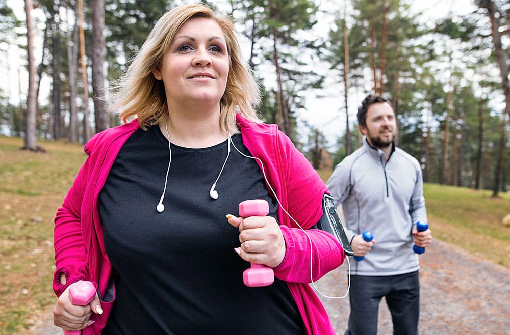 woman outside carrying weights