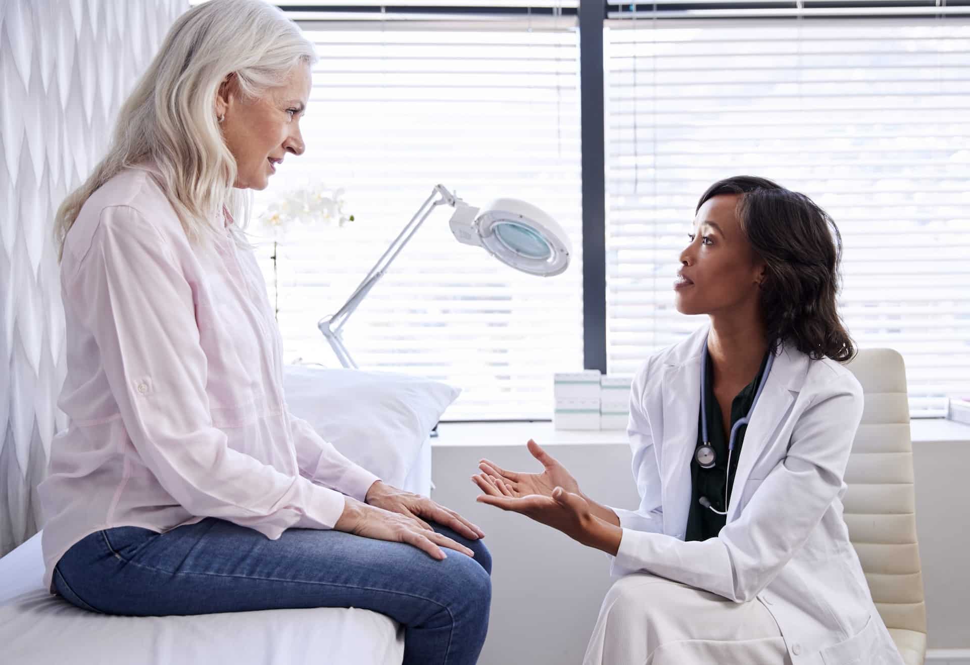 female doctor talking to elderly patient